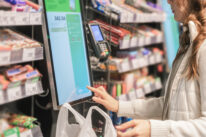 Frau am Selbstcheckout entscheidet sich für Bezahlungsoption