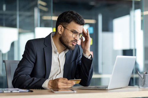 Beitragsbild zeigt einen besorgten Mann, der intensiv einen Monitor studiert