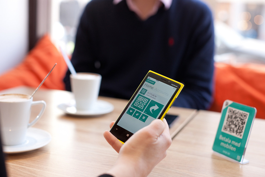 Smartphone wird an QR-Code gehalten